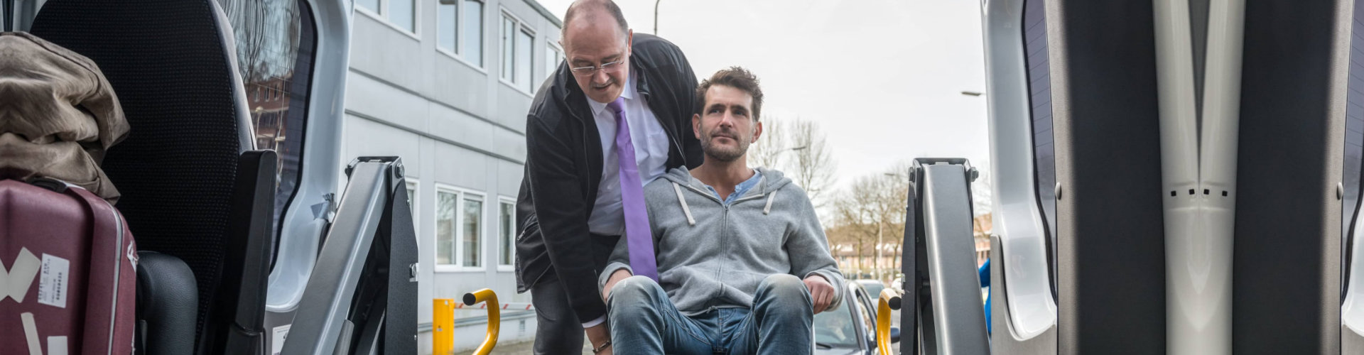 man helping another man on a wheelchair